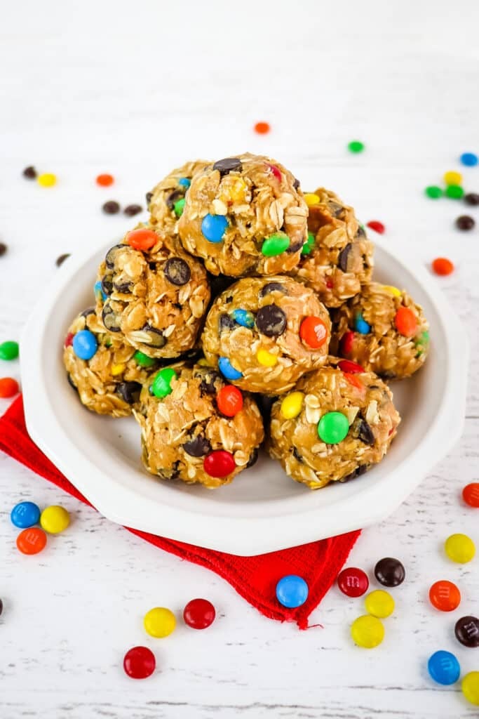 White plate with stack of no bake oatmeal balls with M&M's.