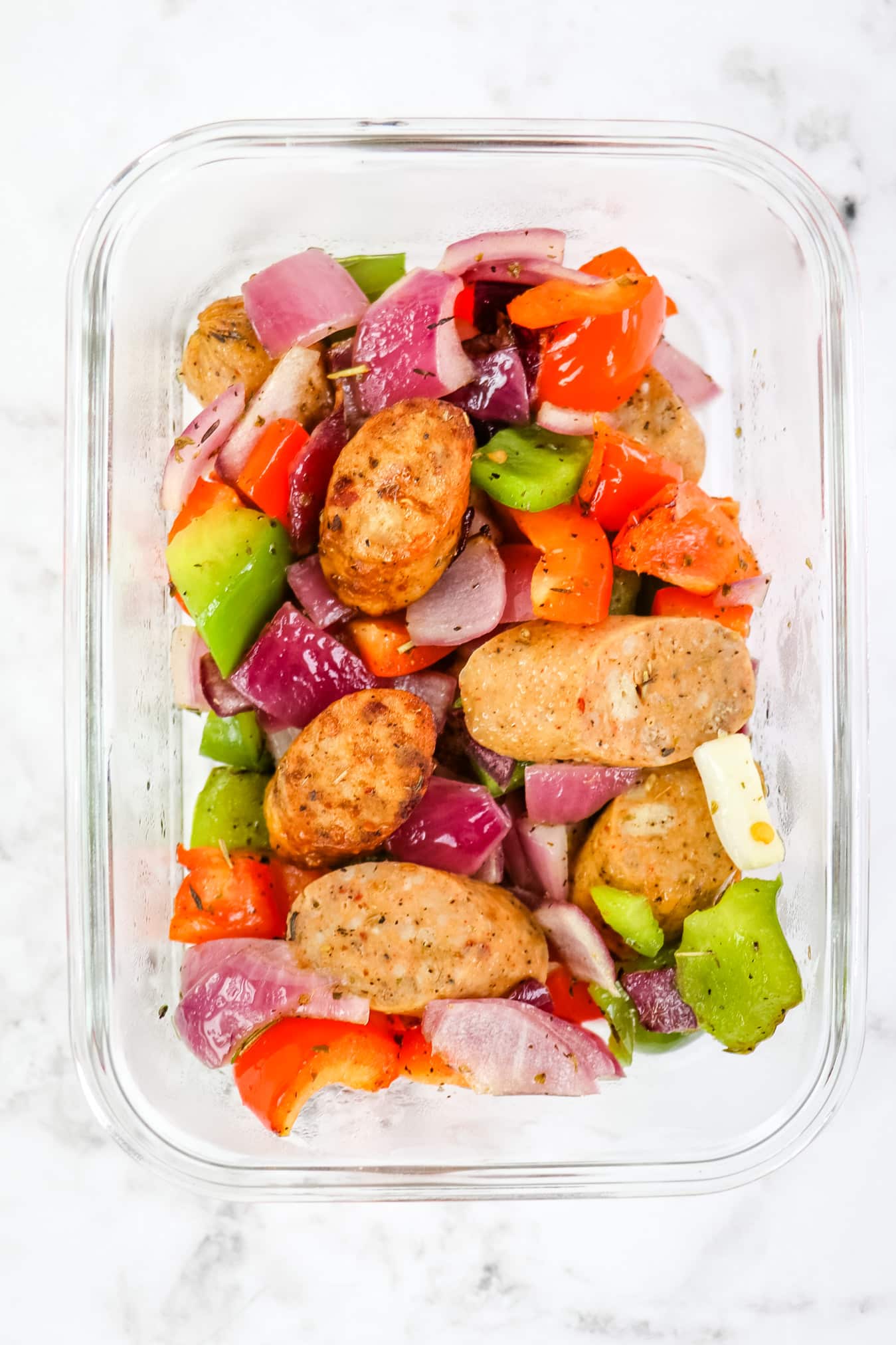 Single meal prep container with air fryer chicken sausage with peppers and onions.