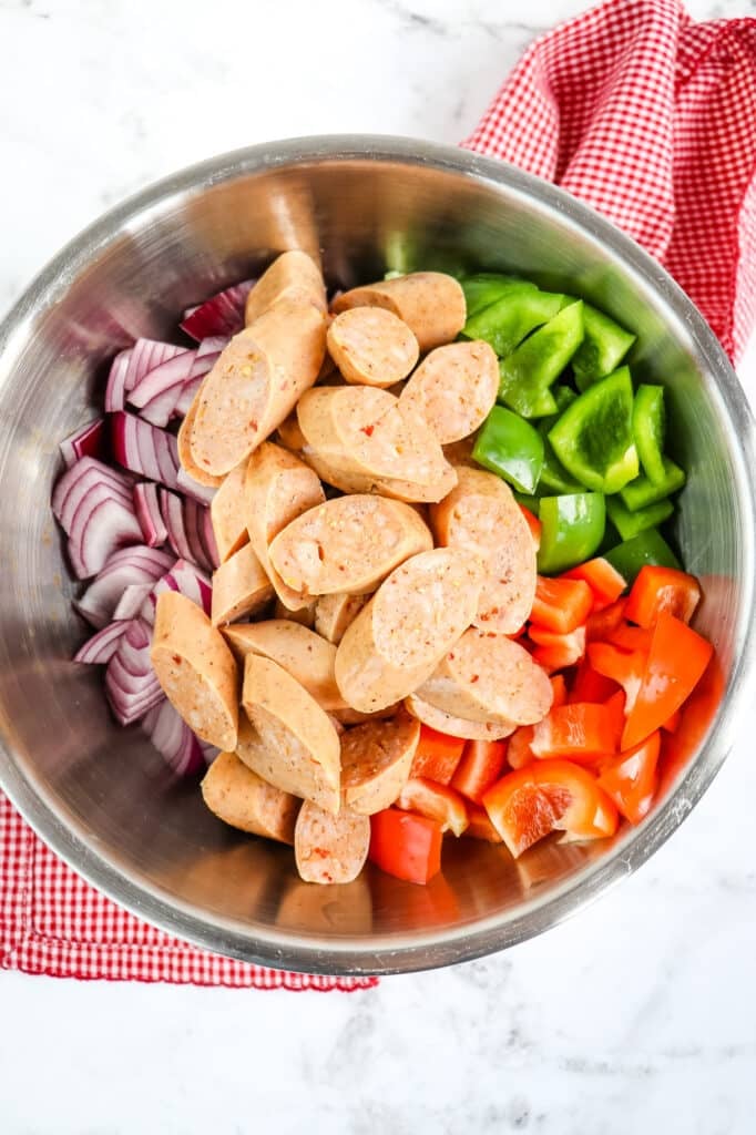 Chopped peppers, onions and chicken sausage in bowl for air fryer chicken sausage recipe.