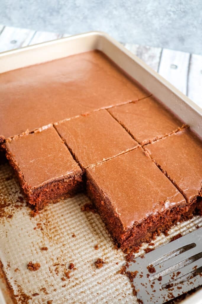 Buttermilk chocolate cake recipe in a 9 x 13" pan, partially cut into squares for serving.