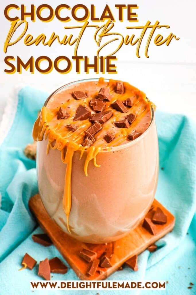 Chocolate peanut butter banana smoothie in a glass topped with peanut butter and chocolate chunks.