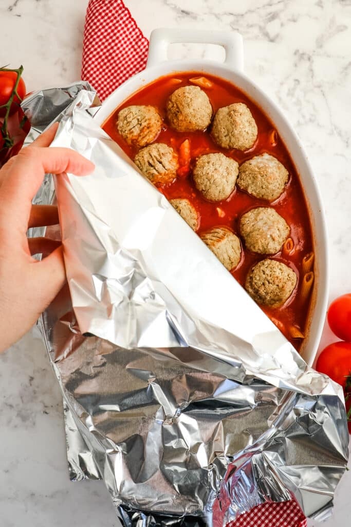 Foil covering the top of a meatball casserole.