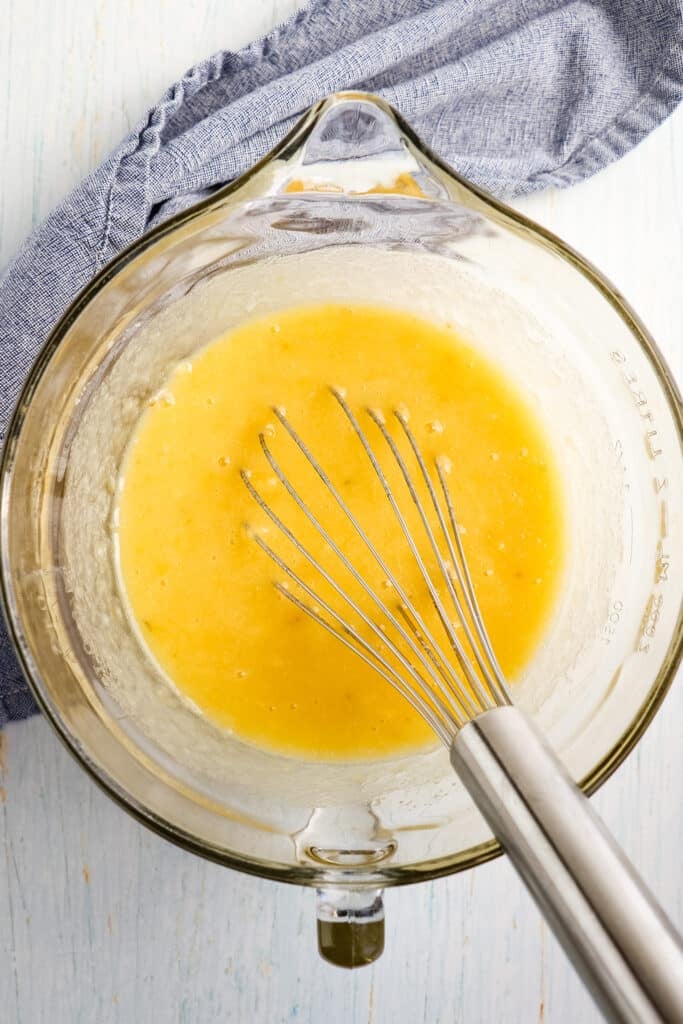 Wet ingredients for award winning banana bread in a mixing bowl with whisk.