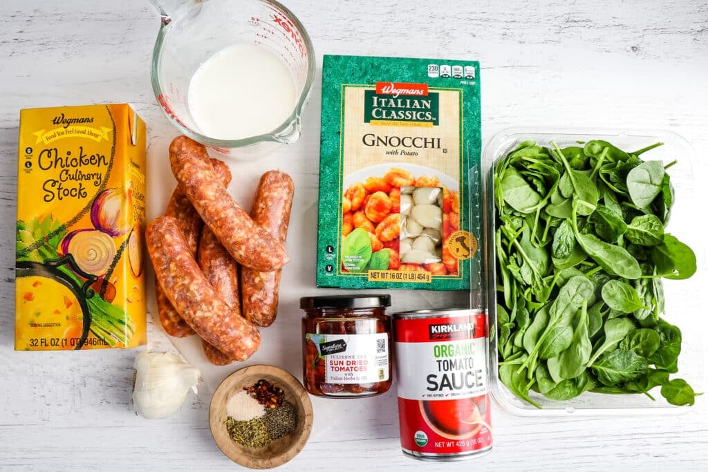 Ingredients needed to make sausage gnocchi in a creamy red sauce.