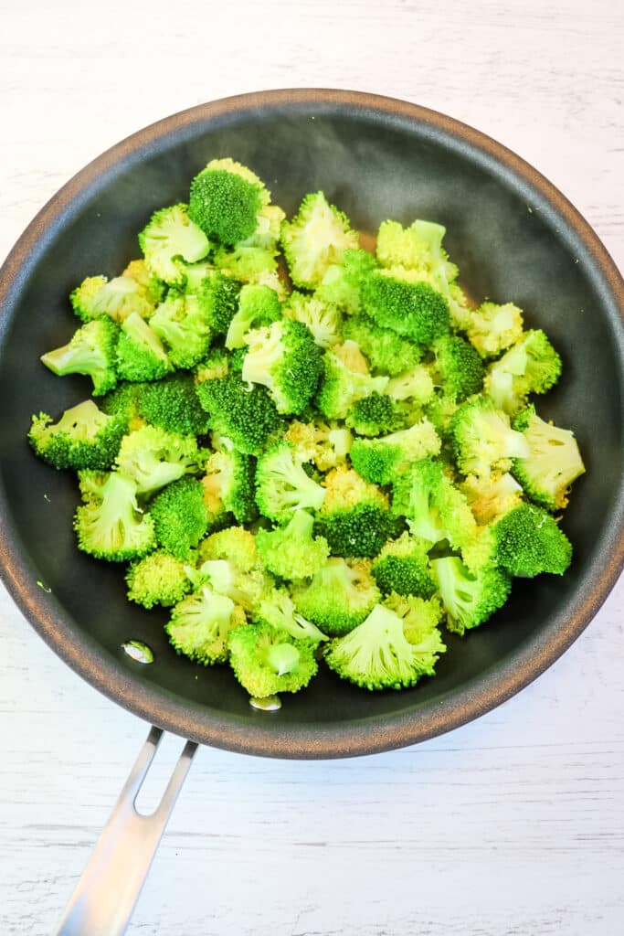 Broccoli in a skillet after being steamed.