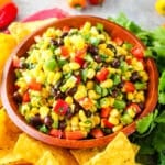 Black bean and corn salsa in a bowl, served along side tortilla chips.
