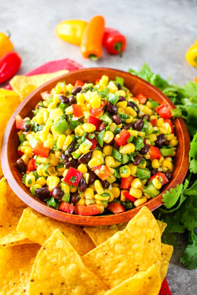 Black bean and corn salsa in a bowl, served along side tortilla chips.