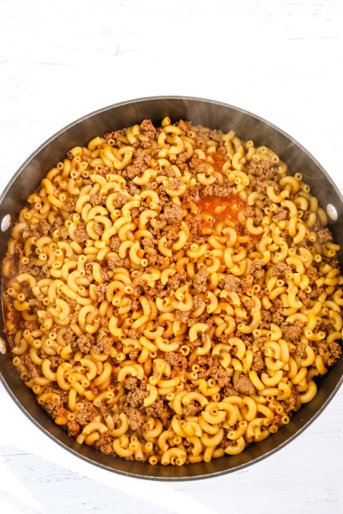 Cooked macaroni and beef in skillet to make cheeseburger macaroni.