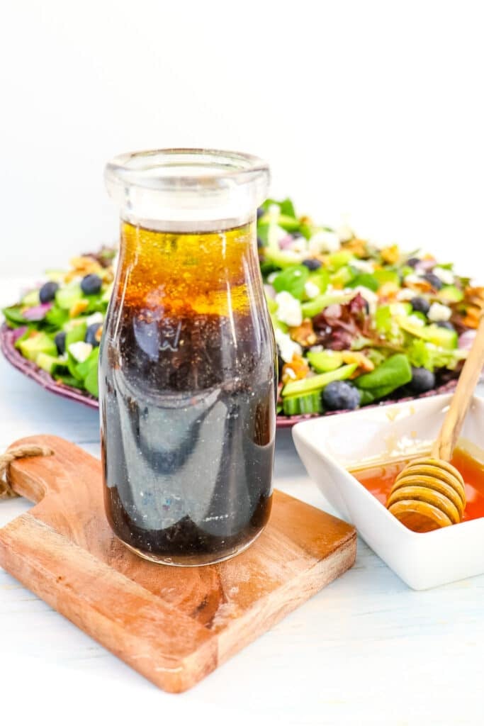 Honey balsamic dressing in a bottle with honey on the side.