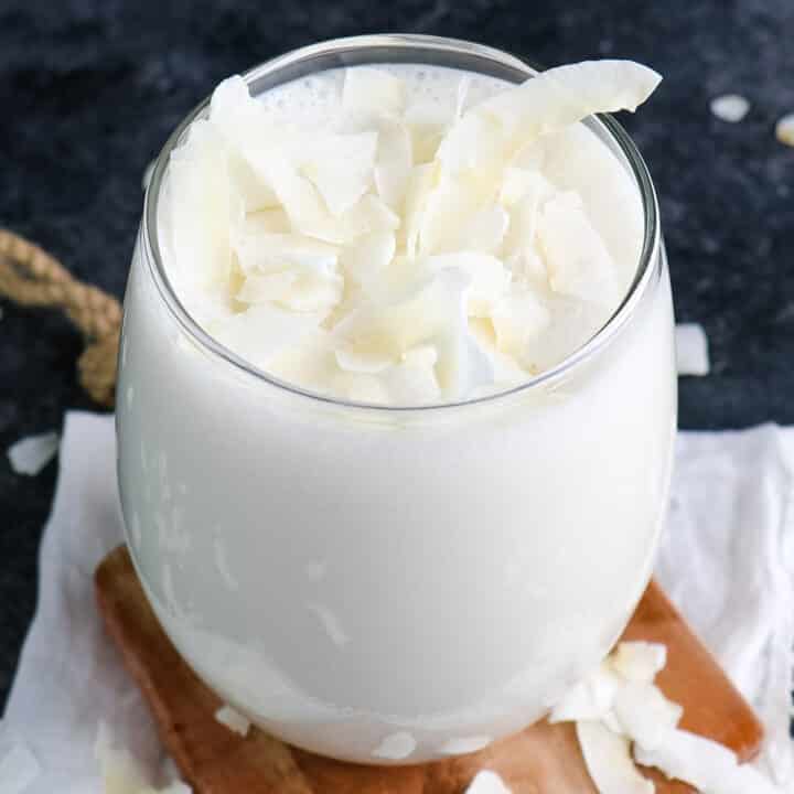 Coconut milk smoothie topped with strands of coconut.