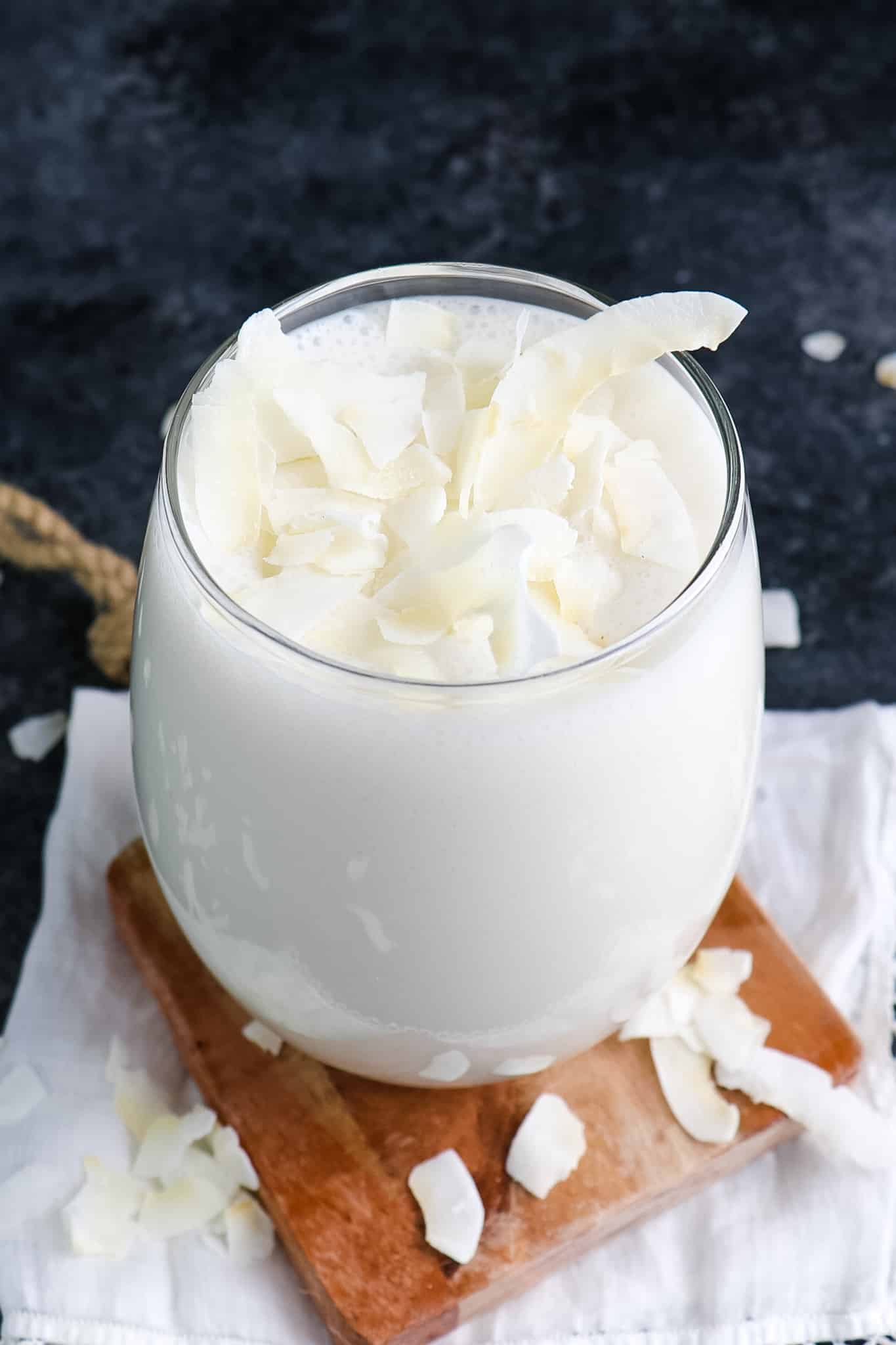 Coconut milk smoothie topped with strands of coconut.