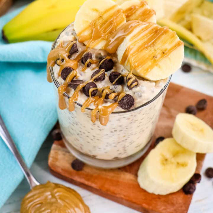 Peanut butter overnight oats in a glass with spoonful of creamy peanut butter on the side.