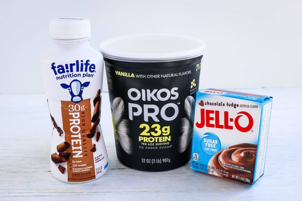 The three ingredients need to make the chocolate protein pudding recipe. Fairlife chocolate protein drink, Oikos Pro yogurt and sugar free chocolate Jello pudding mix.