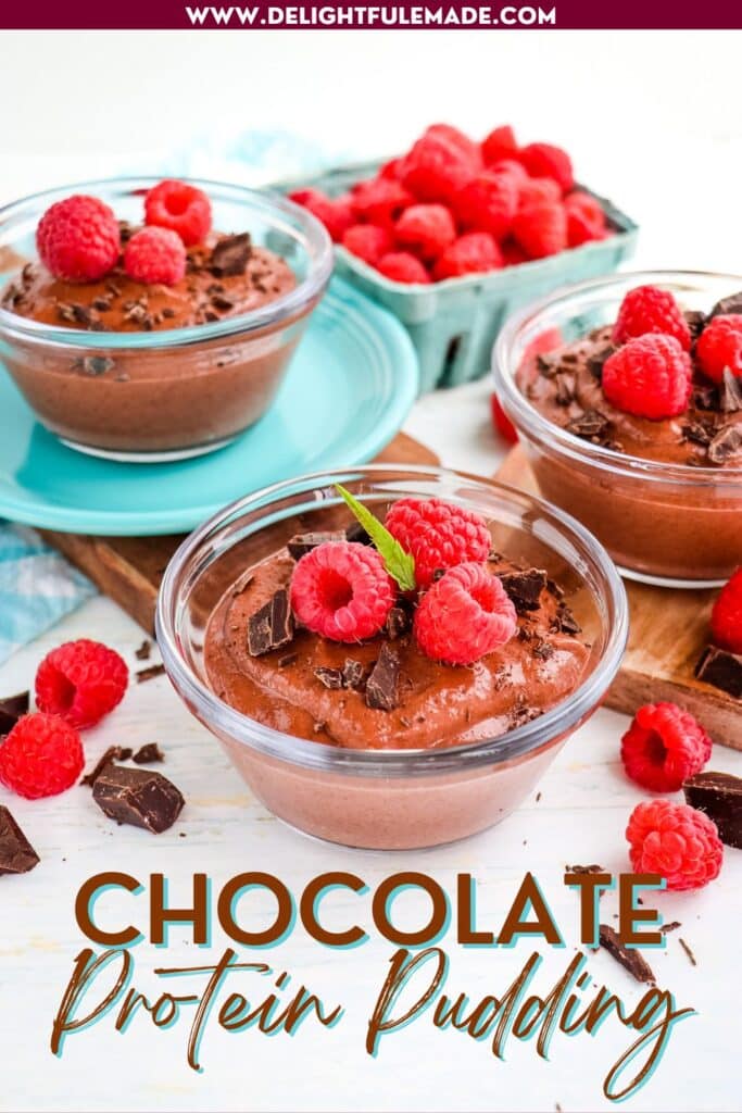 Chocolate protein pudding in three bowls, each topped with chocolate chunks and fresh raspberries.