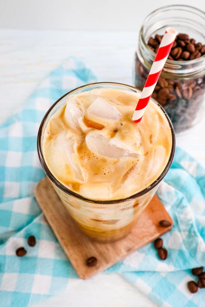 Top down look at the iced caramel latte in a glass with ice.