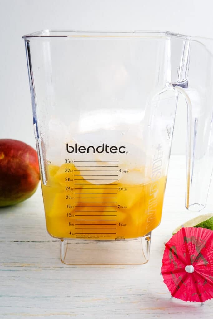 Ingredients for a mango daiquiri in a blender jar, unblended.