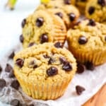 Banana protein muffins with chocolate chips on a board.