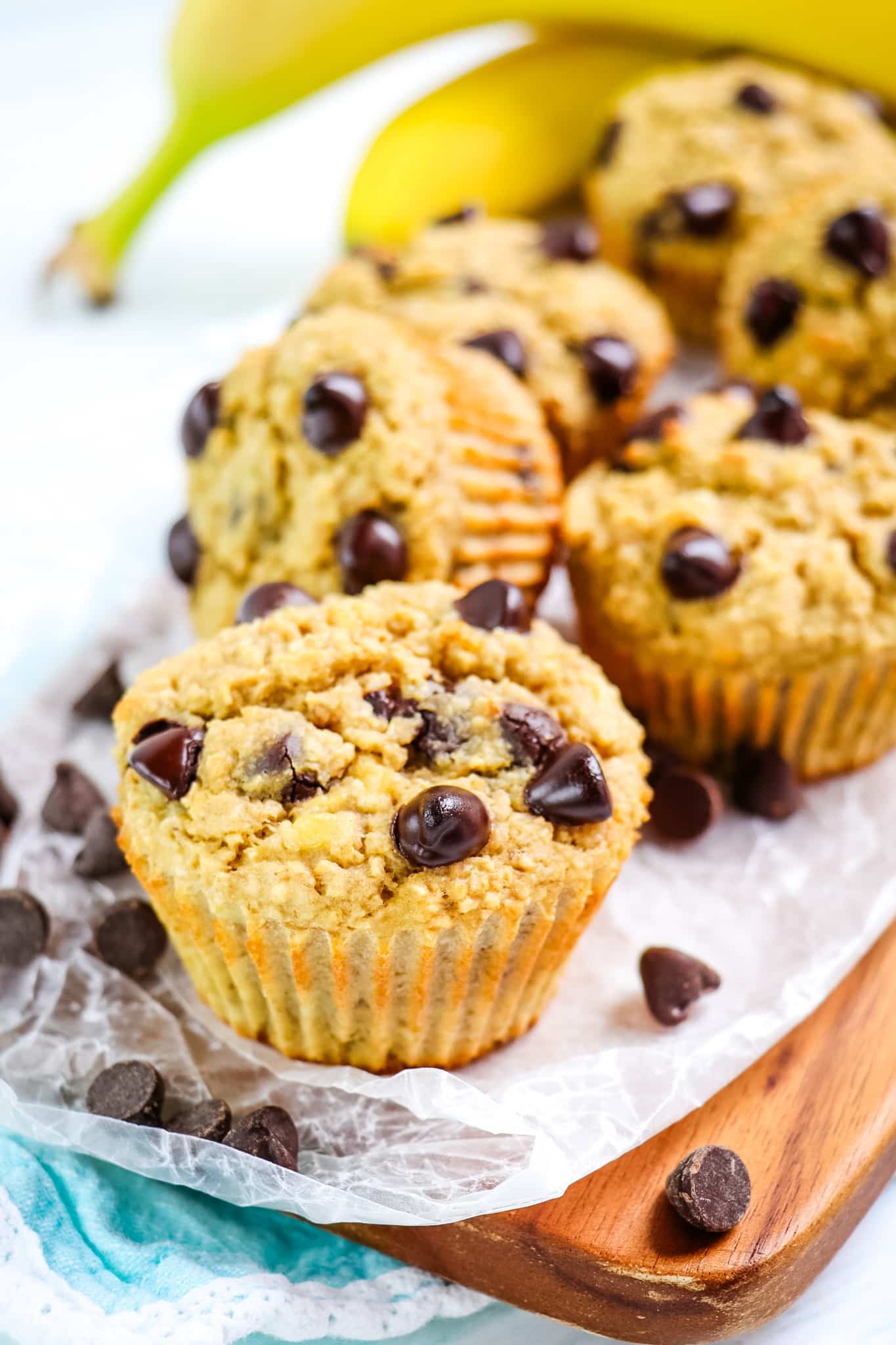 Banana protein muffins with chocolate chips on a board.