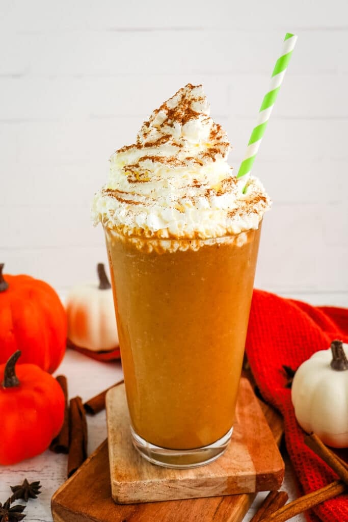 Pumpkin spice frappuccino recipe in a tall glass topped with whipped cream and cinnamon.