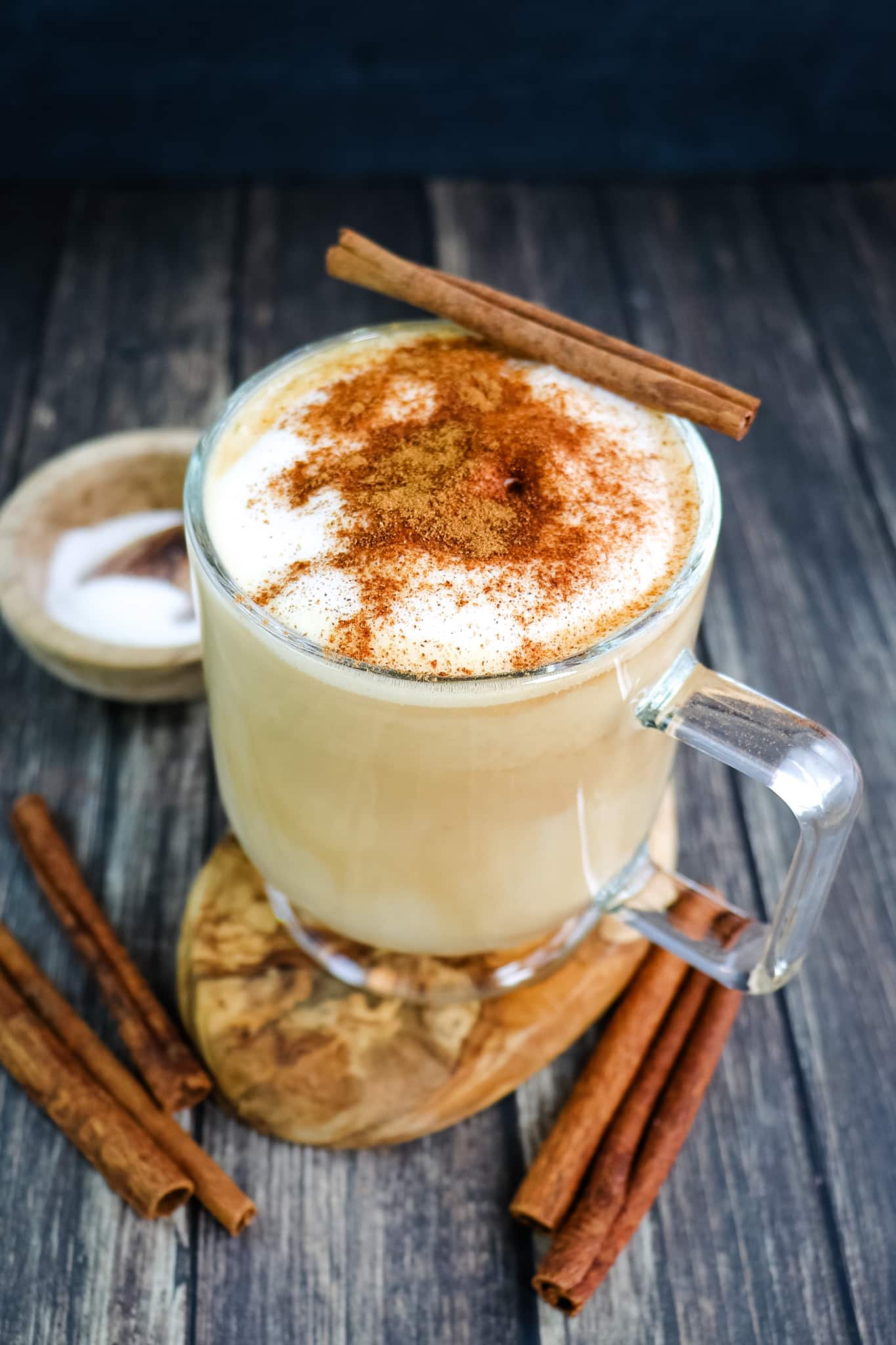 A cinnamon dolce latte topped with ground cinnamon and a cinnamon stick.