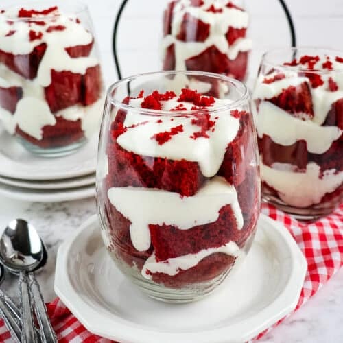Red velvet cake parfaits layered with cream cheese custard and topped with red velvet crumbs.