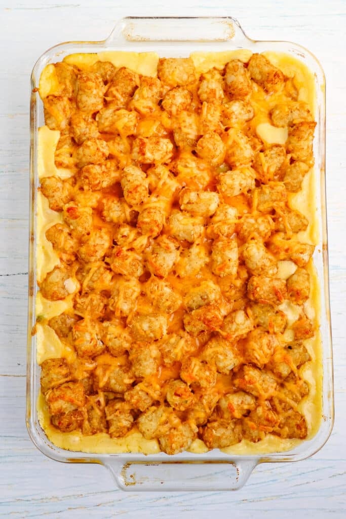 Chicken tater tot casserole baked and topped with shredded cheddar cheese.