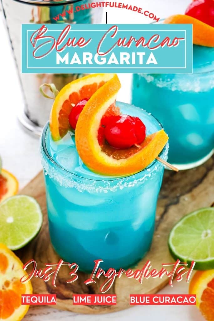 Blue margarita drink recipe topped with orange and cherry garnish and with salt on the rim of the glass.