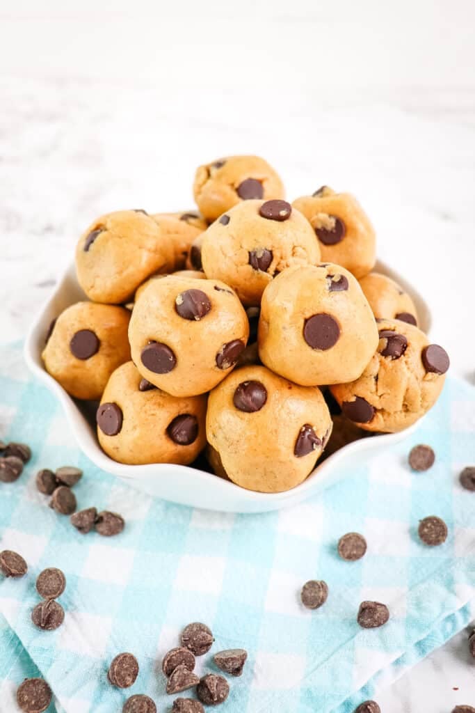 Low carb protein balls in a white dish with chocolate chips sprinkled on the side.