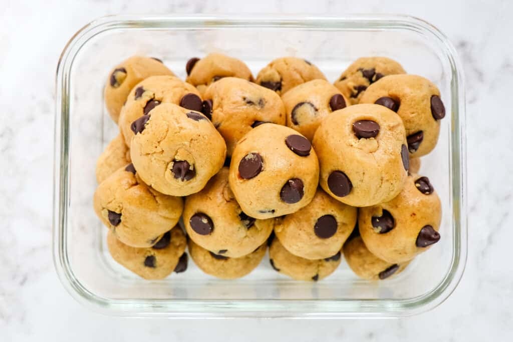 Cookie dough protein balls in a glass meal prep container.