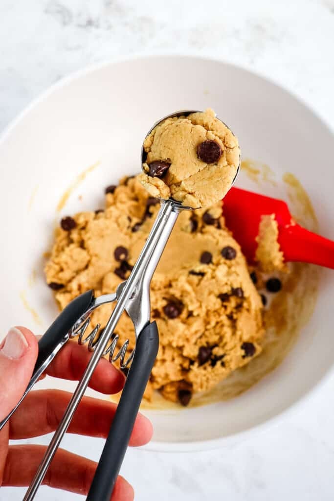 Cookie scoop with chocolate chip protein balls dough inside the scoop.