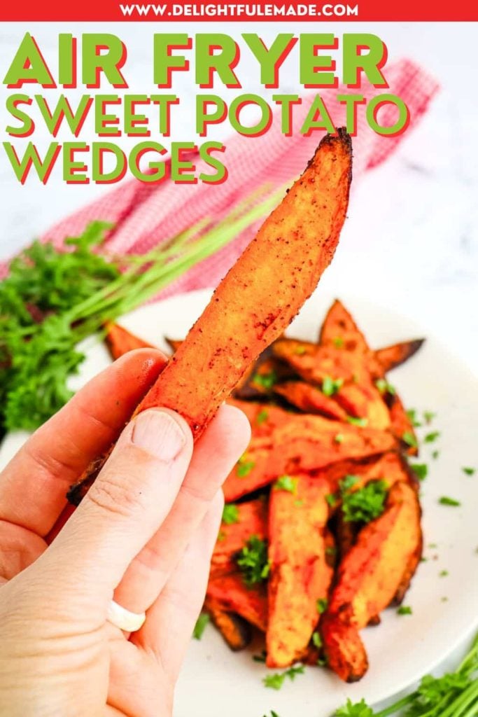 Air fryer sweet potatoes on a plate and one sweet potato wedge held in hand.