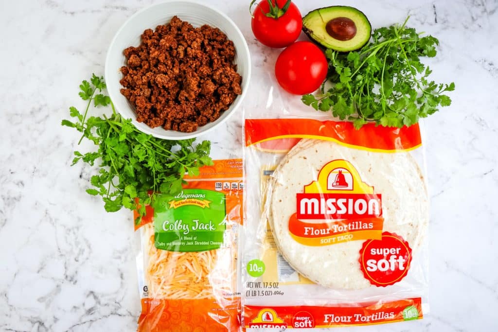 Ingredients needed to make beef quesadillas; seasoned ground beef, shredded cheese and a package of flour tortillas.