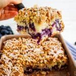 Slice of sour cream blueberry coffee cake being lifted out of the pan on a spatula.