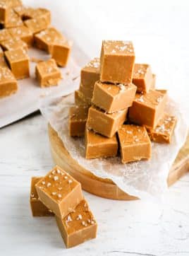 Squares of salted caramel fudge stacked on top of each other.