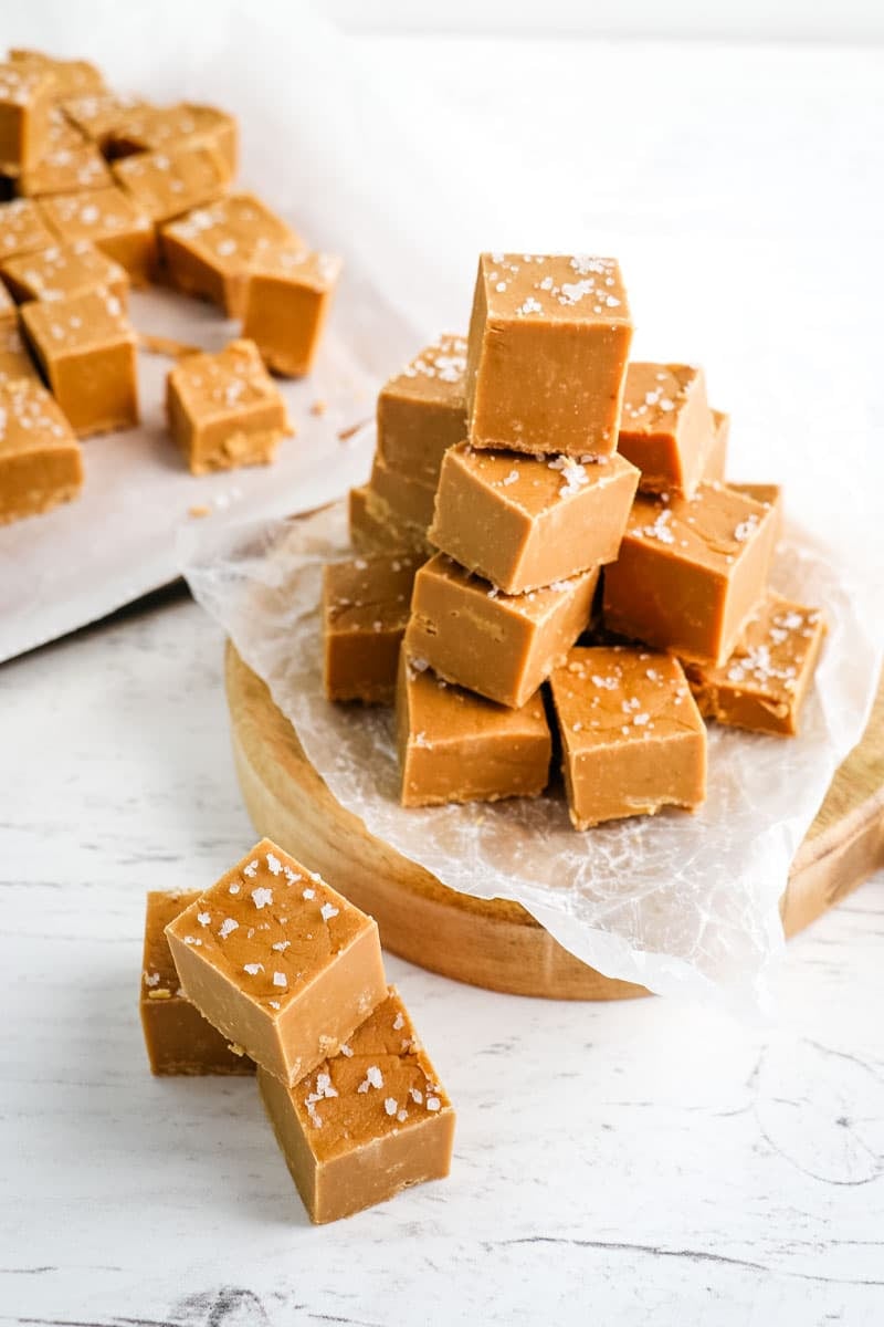 Squares of salted caramel fudge stacked on top of each other.