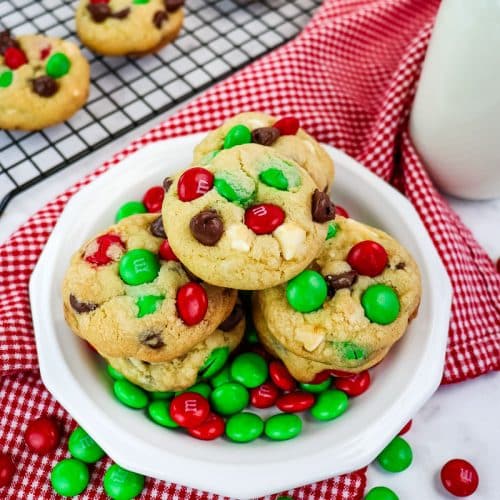 Plate of Christmas M&M cookies on a plate with red and green M&M's on the side.