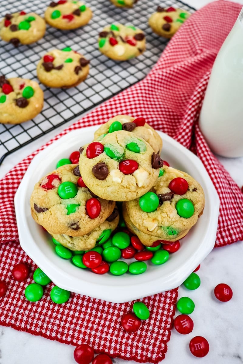 Plate of Christmas M&M cookies on a plate with red and green M&M's on the side.