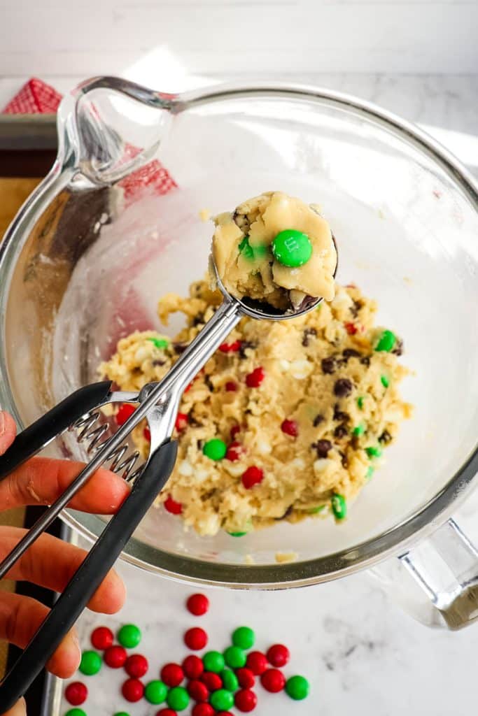 Cookie dough being formed with a cookie scoop.