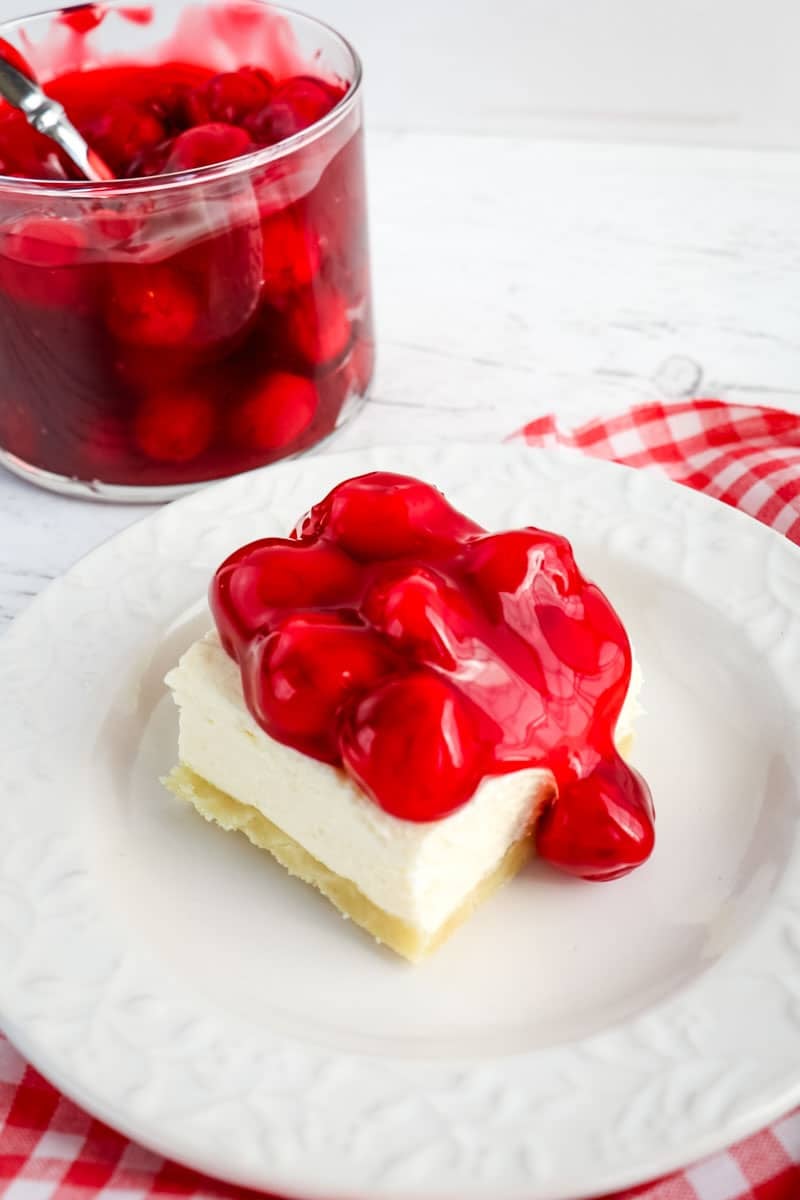 Slice of no bake cherry cheesecake topped with cherry sauce.