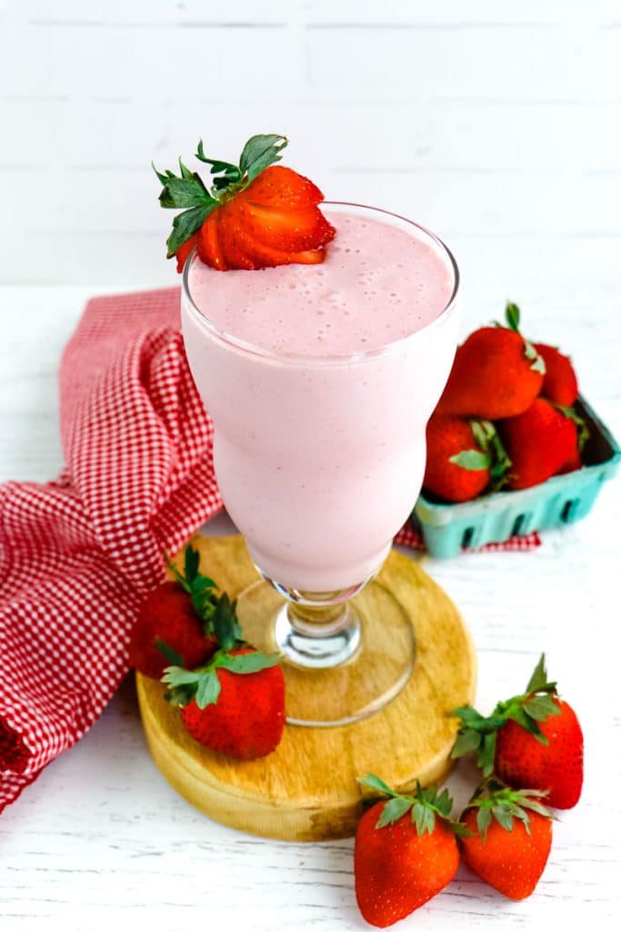 A strawberry cottage cheese smoothie topped with a fresh sliced strawberry.
