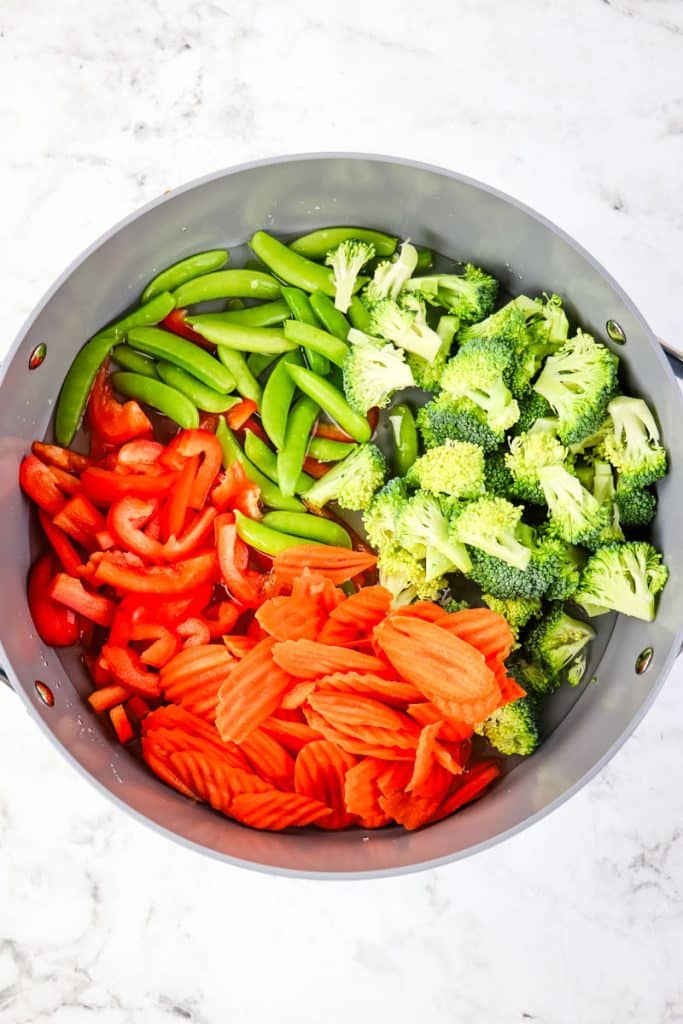 Fresh vegetables in a large skillet to be steamed.