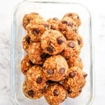 Pumpkin chocolate chip protein balls placed in a glass meal prep container.