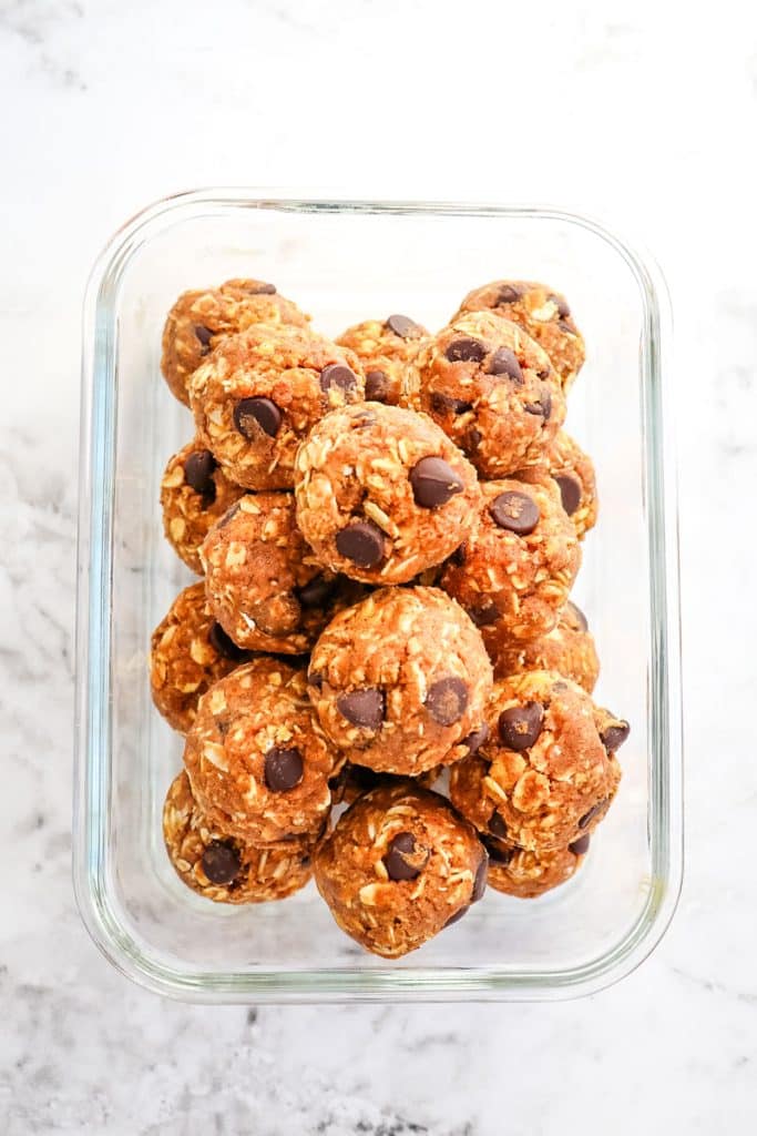 Pumpkin chocolate chip protein balls placed in a glass meal prep container.