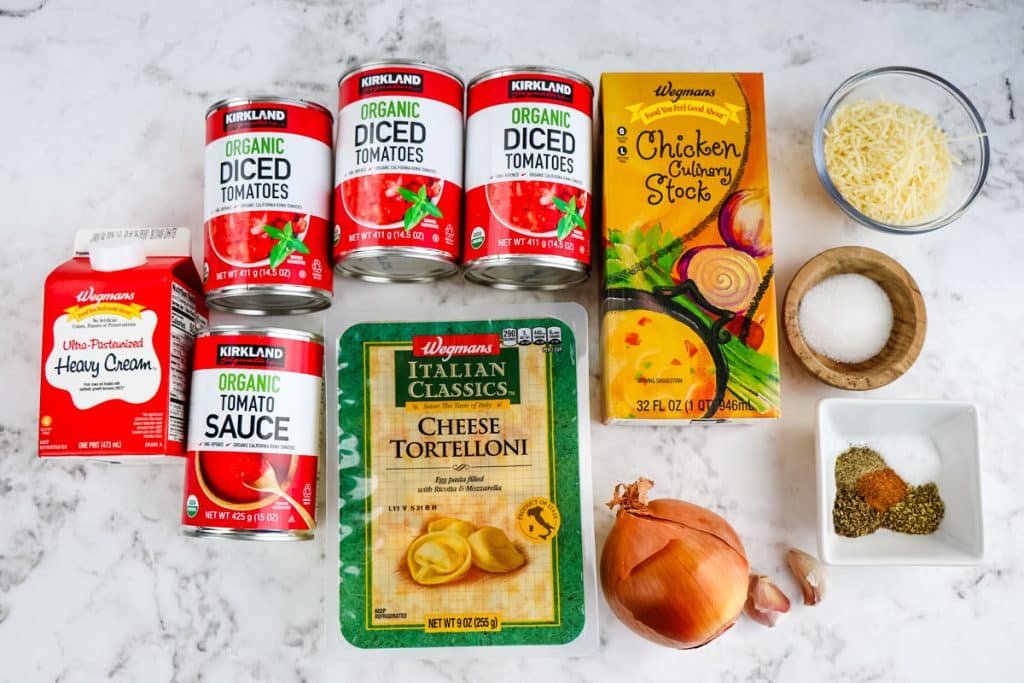 Ingredients needed to make tomato and tortellini soup.