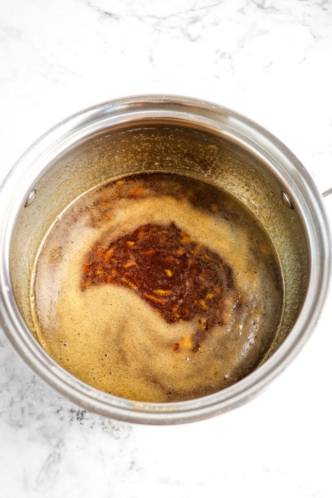 Orange glaze in saucepan after being heated.
