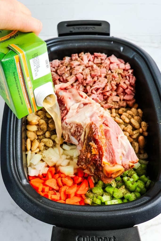Broth being poured into the ham and bean soup.