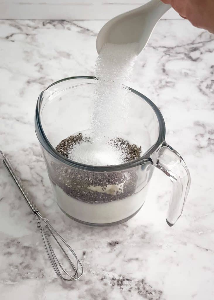 Granular sweetener being added to the chia seed pudding mixture.