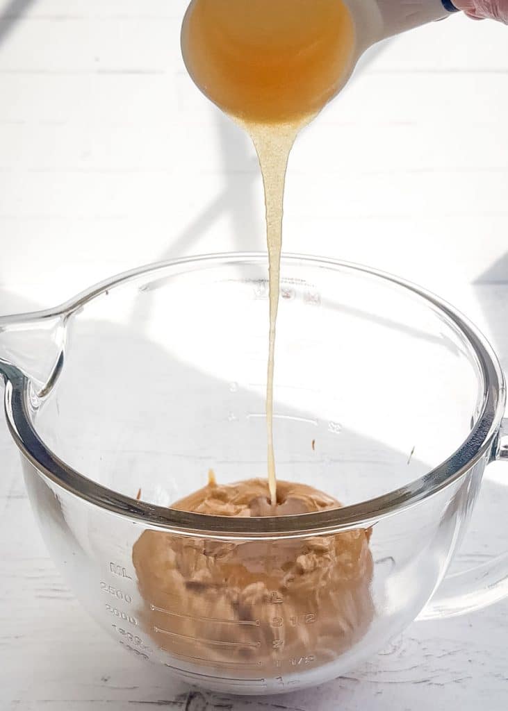 Honey being added to peanut butter for protein powder protein balls.