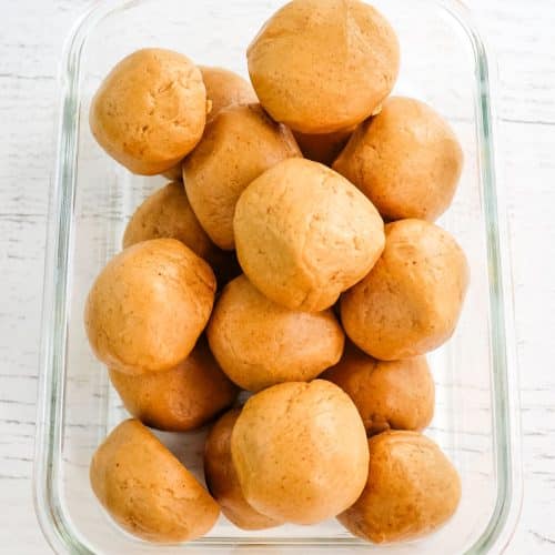 Peanut butter protein balls in a glass meal prep container.