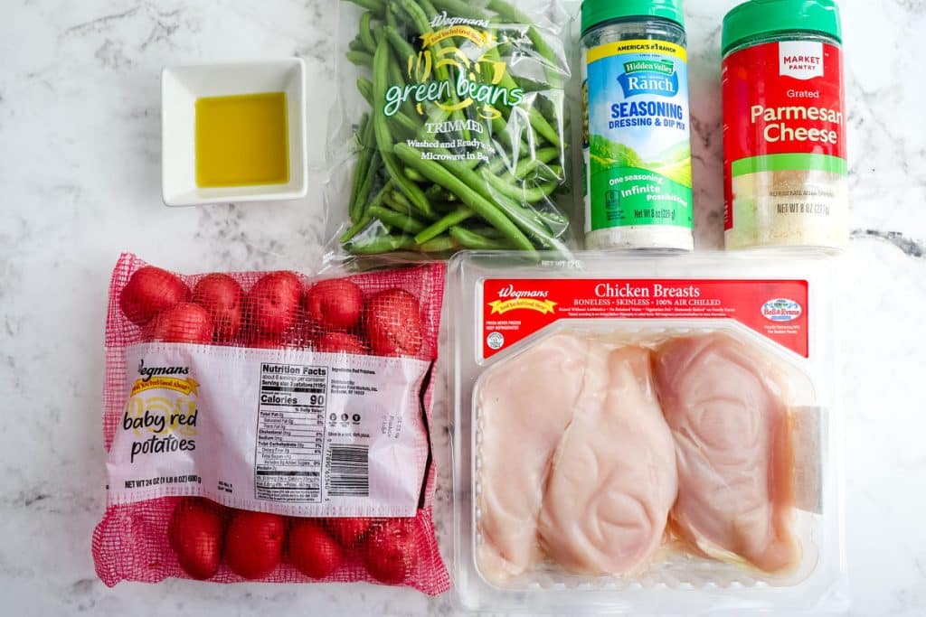 Ingredients needed to make sheet pan ranch chicken and potatoes; chicken breasts, baby potatoes, grated parmesan, hidden valley ranch seasoning mix, fresh green beans and olive oil.
